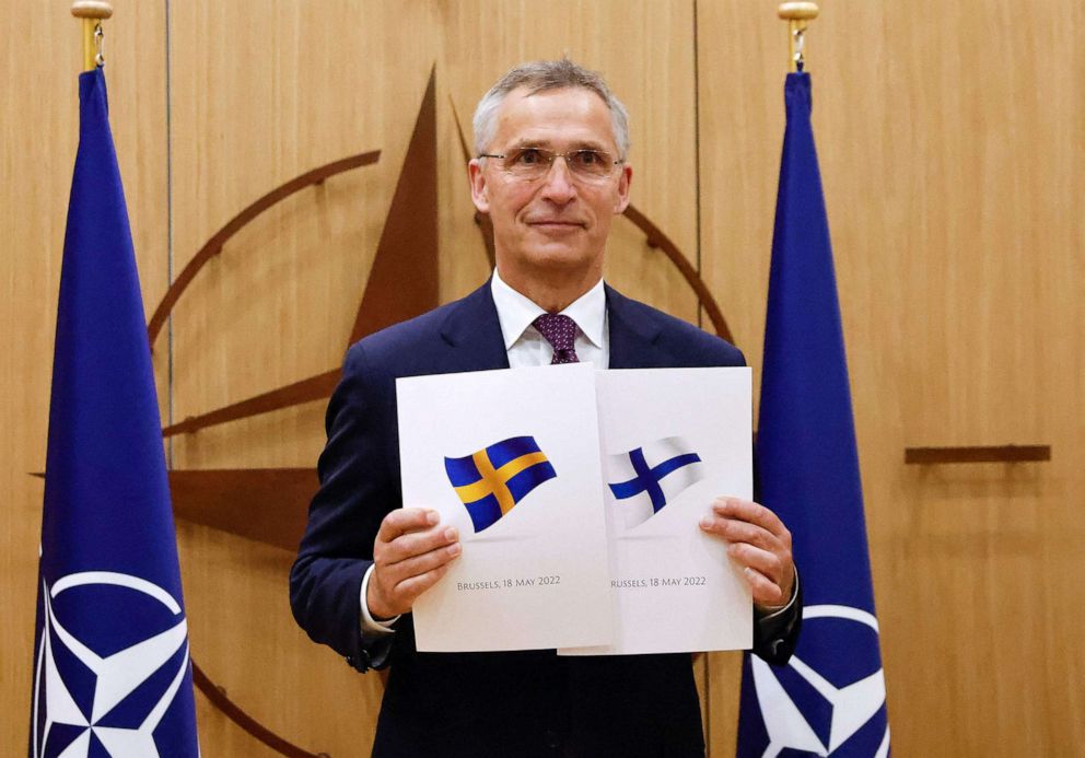 NATO Secretary-General Jens Stoltenberg poses with documents presented by Finland's Ambassador to NATO Klaus Korhonen and Sweden's Ambassador to NATO Axel Wernhoff during a ceremony to mark the applications for membership in Brussels, on May 18, 2022.