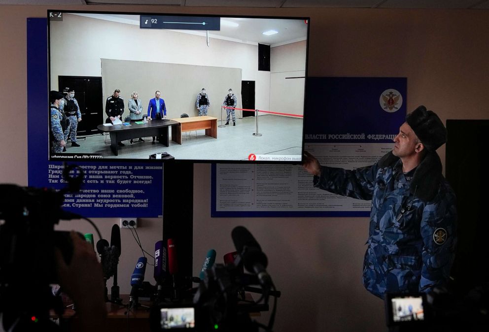 PHOTO: An officer of Russian Federal Penitentiary Service touches a TV screen translating a court session of Russian opposition leader Alexei Navalny in Russia on March 22, 2022.