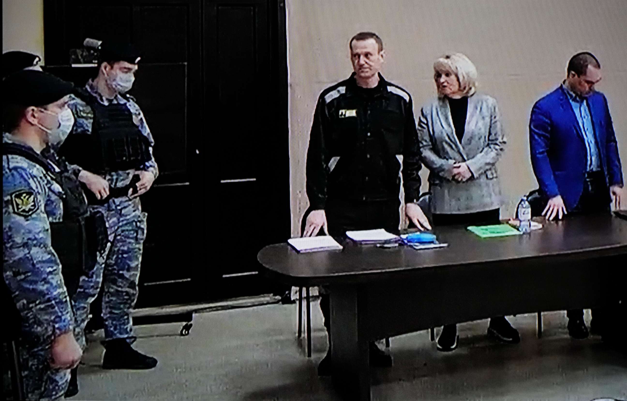 PHOTO: Russian opposition leader Alexei Navalny, center, is seen via a video link provided by the Russian Federal Penitentiary Service, standing next to his layers during a court session in Pokrov, Vladimir region, Russia, on March 22, 2022.