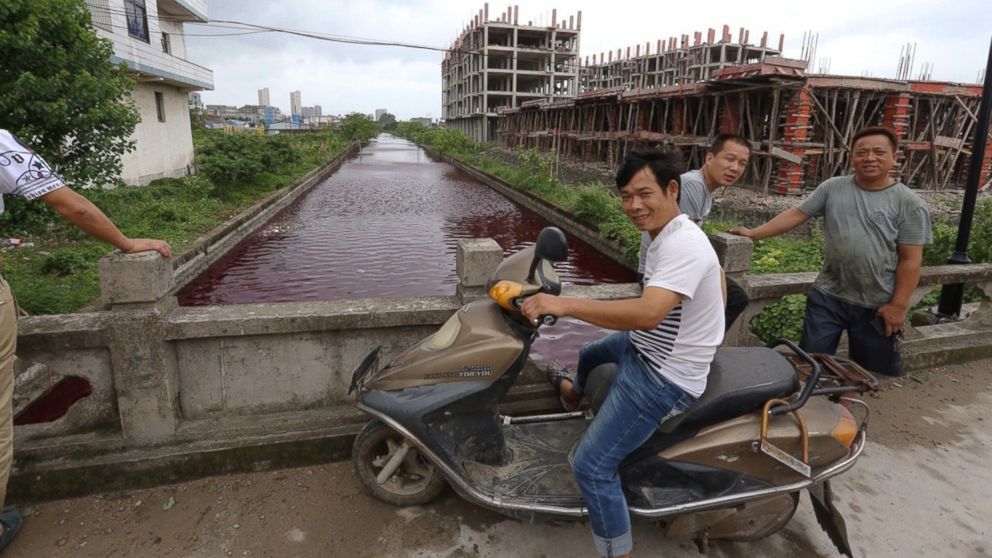 PHOTO: The river in Xinmeizhou village in eastern China's Zhejiang province quickly filled up with the red colored liquid which had a strange smell, according to villagers, July 25, 2014.