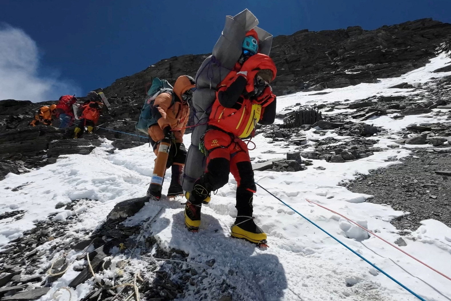 PHOTO: Ngima Tashi Sherpa walks as he carries a Malaysian climber while rescuing him from the death zone above camp four at Everest, Nepal, May 18, 2023, in this screengrab obtained from a handout video.