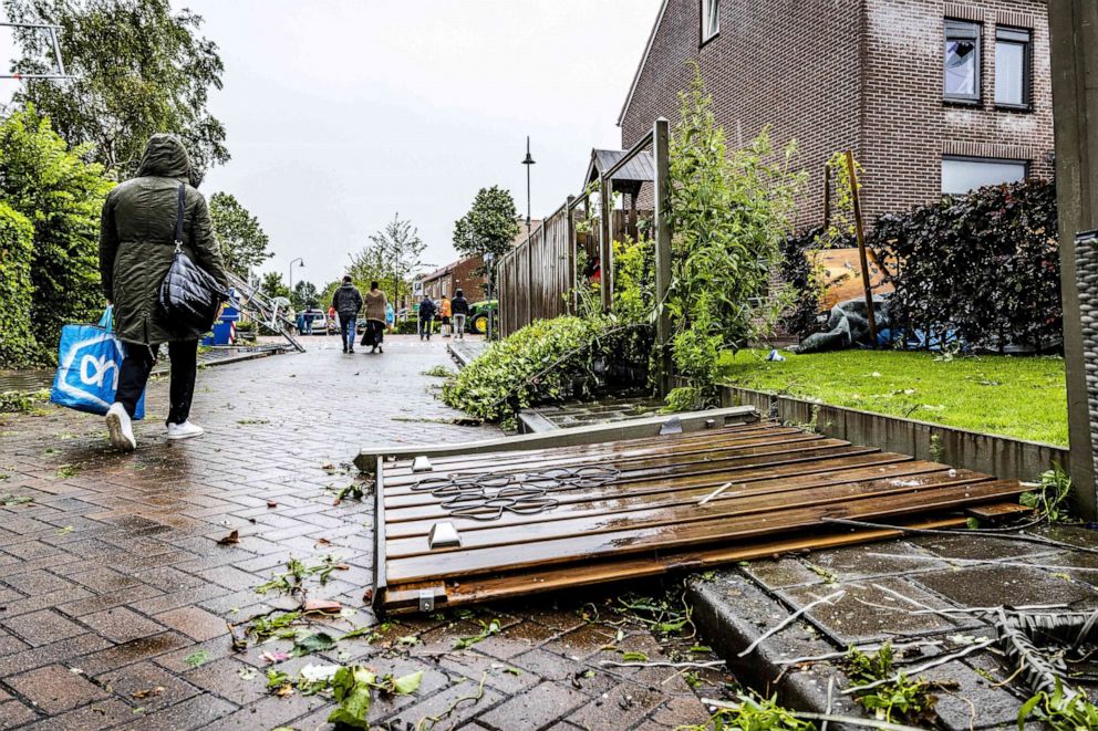 PHOTO: A woman walks past a damaged wooden fence after a tornado hit Zierikzee, Netherlands, June 27, 2022.