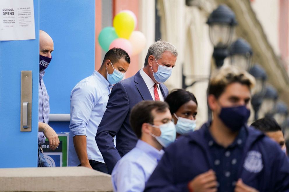 PHOTO: New York City Mayor Bill de Blasio (rear center) leaves Public School 188 The Island School in Manhattan after students arrived for in-person classes on Sept. 29, 2020. 