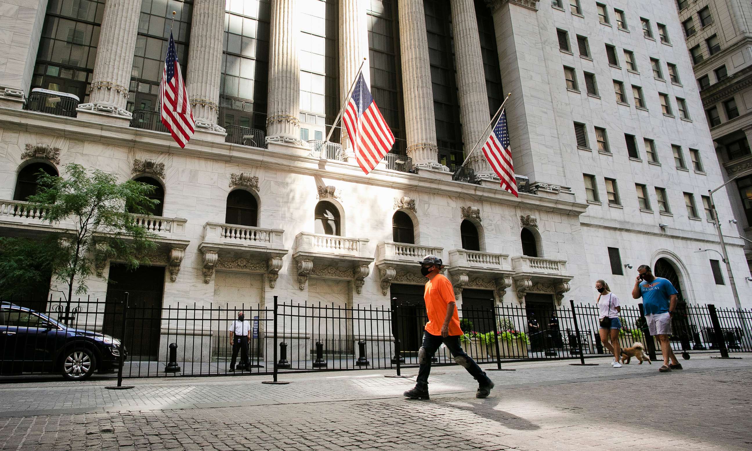 PHOTO: People walk by the New York Stock Exchange, July 21, 2020, in New York.