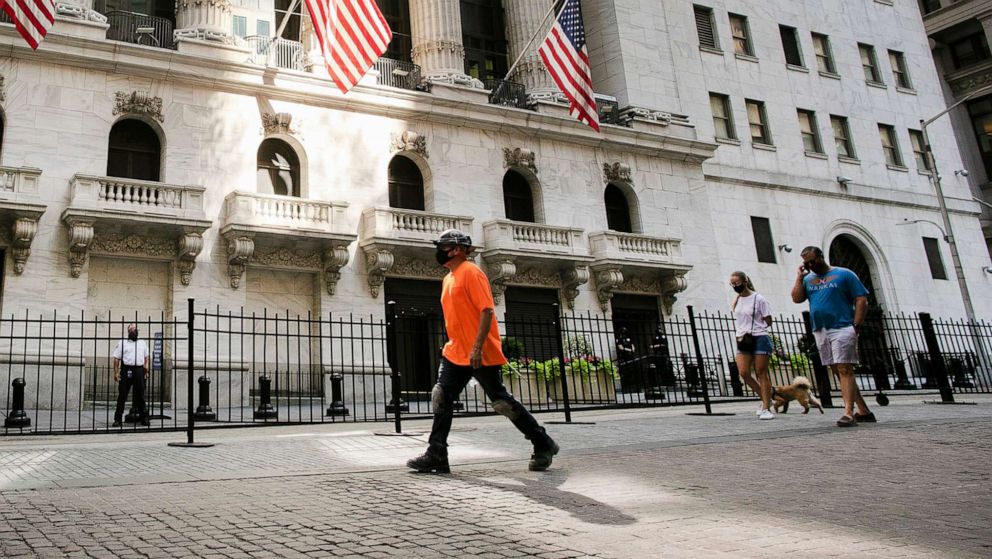 PHOTO: People walk by the New York Stock Exchange, July 21, 2020, in New York.