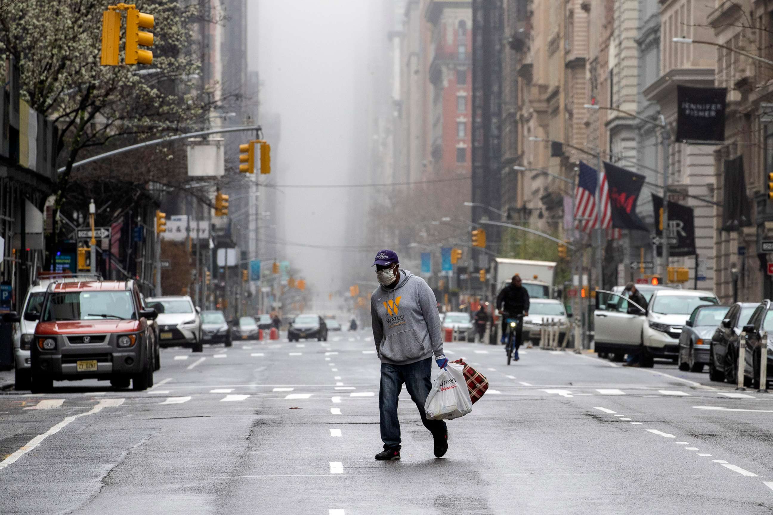 PHOTO: A man wearing a facial mask walks across the middle of 5th Avenue in New York City, March 29, 2020.