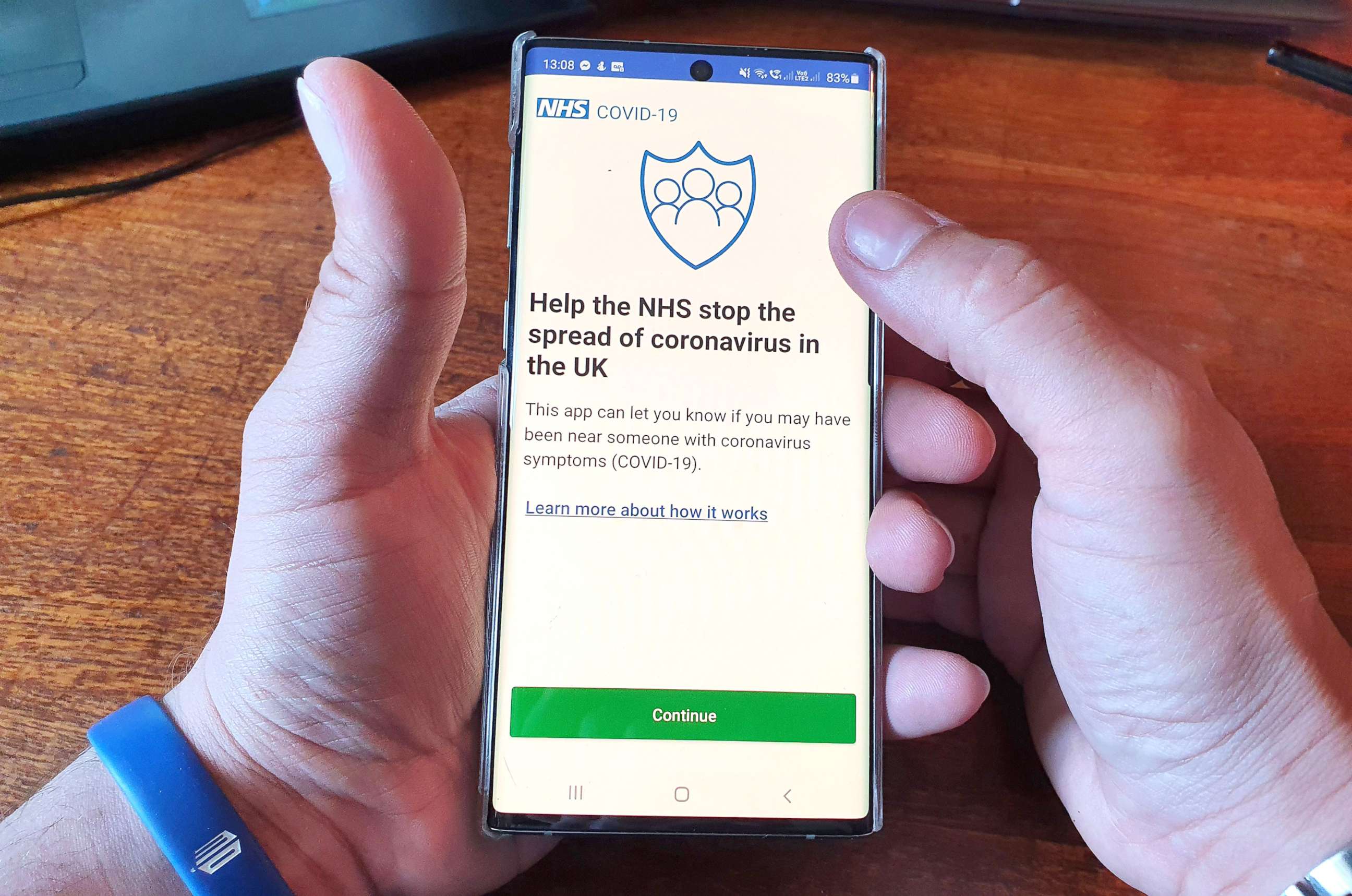 PHOTO: A resident of the Isle of Wight poses with his smartphone showing the newly released NHS Coronavirus contact tracing app in Ryde, May 8, 2020. 