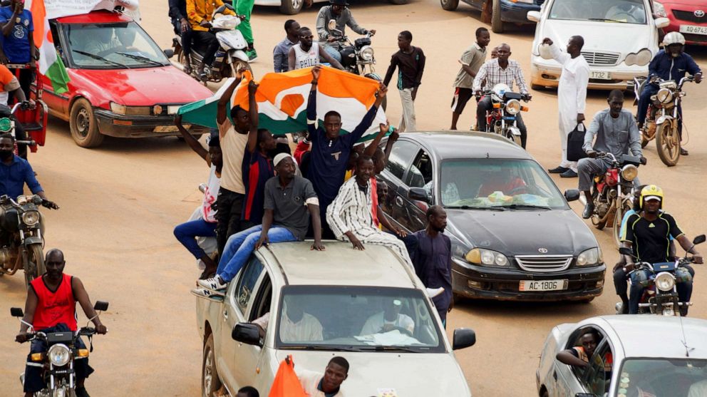 PHOTO: Protestors hold the Niger flag as they arrive to gather in support of the putschist soldiers in the capital Niamey, Niger August 3, 2023.