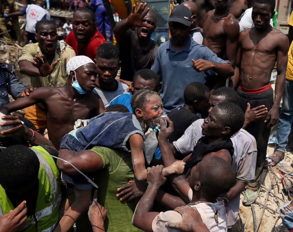 PHOTO: Rescue workers help carry a child at the site of a collapsed building containing a school in Nigeria's commercial capital of Lagos, Nigeria, March 13, 2019.