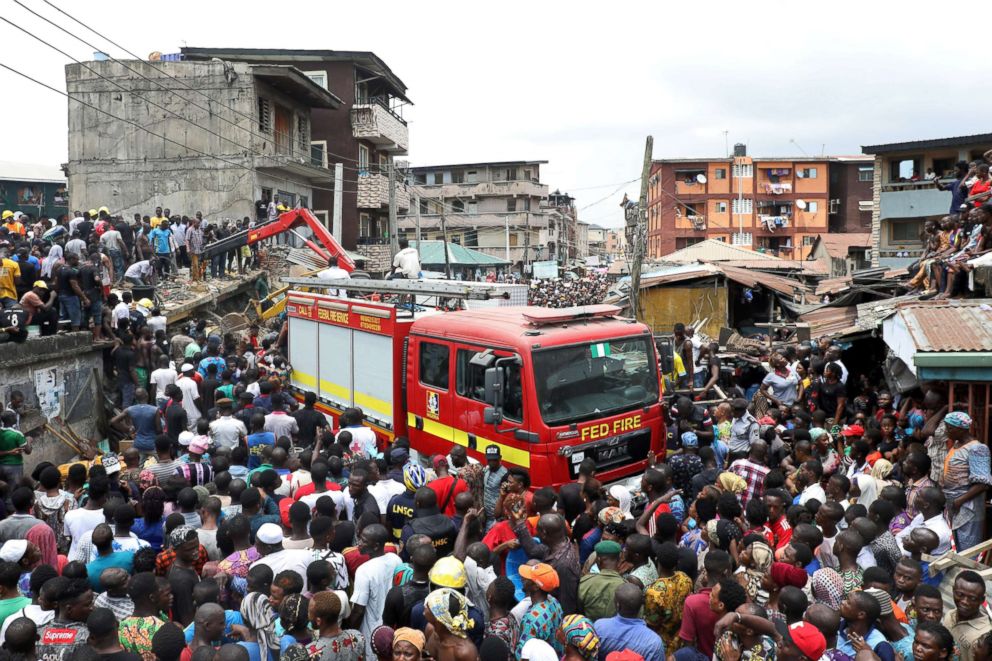 PHOTO: People gather as rescue workers search for survivors at the site of a collapsed building containing a school in Nigeria's commercial capital of Lagos, Nigeria, March 13, 2019.