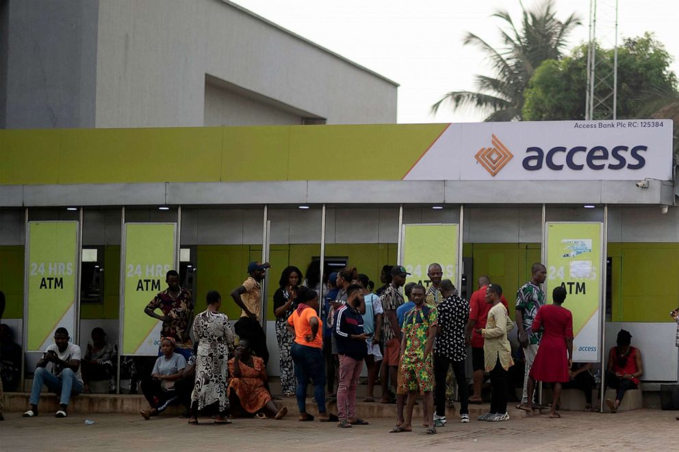 PHOTO: People wait in front of a bank as they attempt to withdraw cash from their savings in Anambra state, southeastern Nigeria, on Feb. 24, 2023.