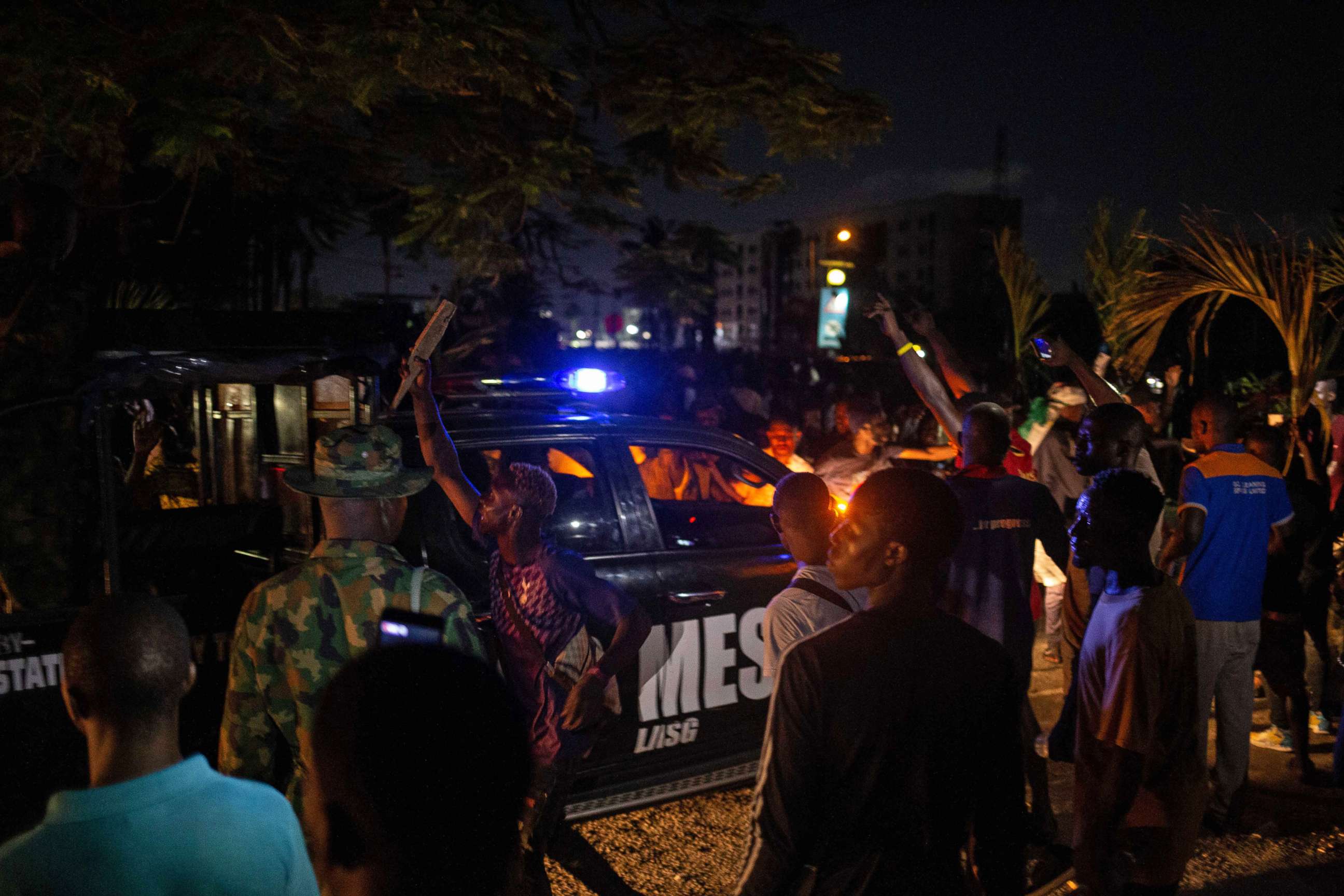 PHOTO: A patrol car of the Lagos State Security drives through Nigerian protesters demonstrating in the streets of Alausa Ikeja on October 20, 2020, after the authorities declared an open-ended lock down in Lagos.