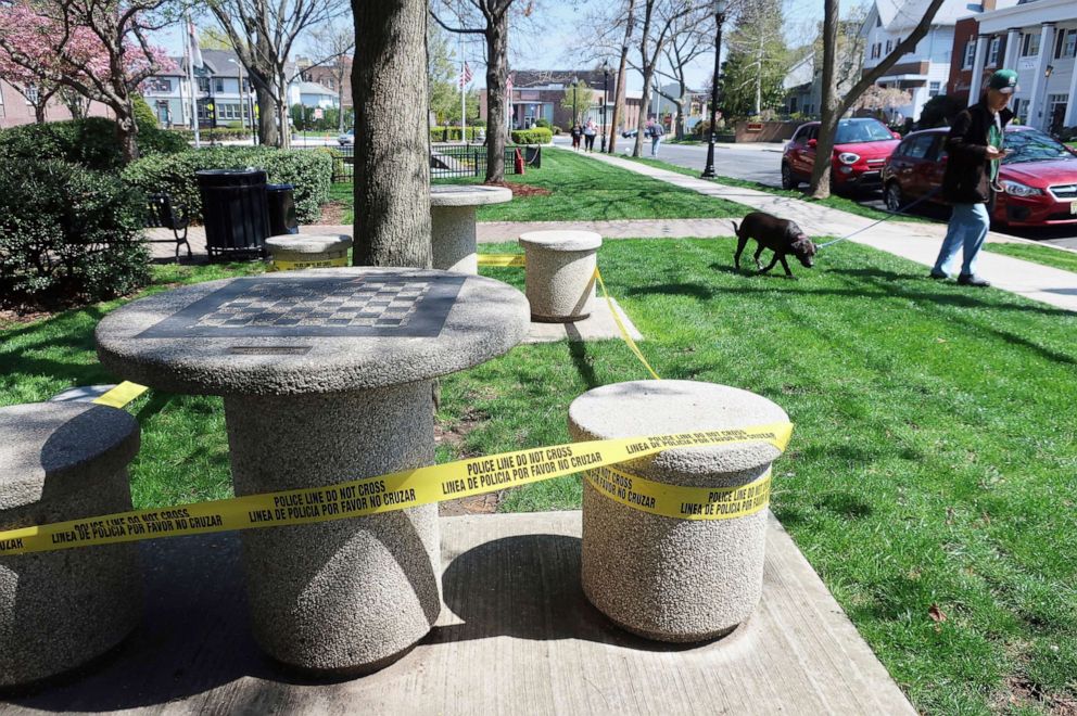 PHOTO: Police tape is wrapped around outdoor public seating areas in Rutherford, N.J., to enforce social distancing during the coronavirus pandemic, April 19, 2020.