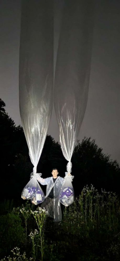 PHOTO: Leader of human rights NGO Park Sang Has holds balloons up in the sky, aiming to fly them at the North Korean border, June 28, 2022.