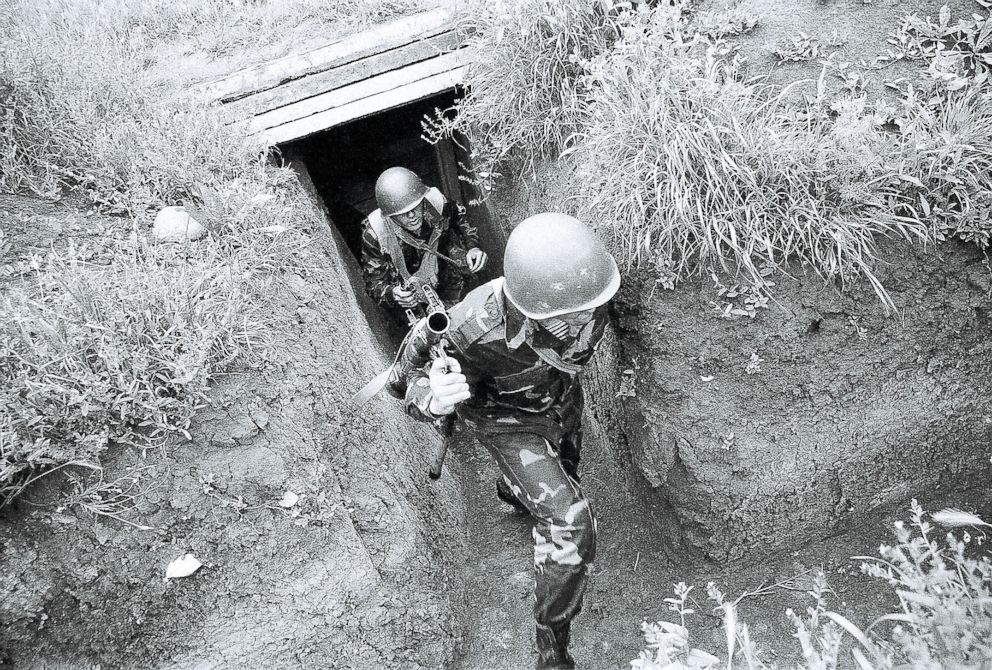 PHOTO: A pair of NKR soldiers are rushing out of their bunker during an Azeri sniper attack. 