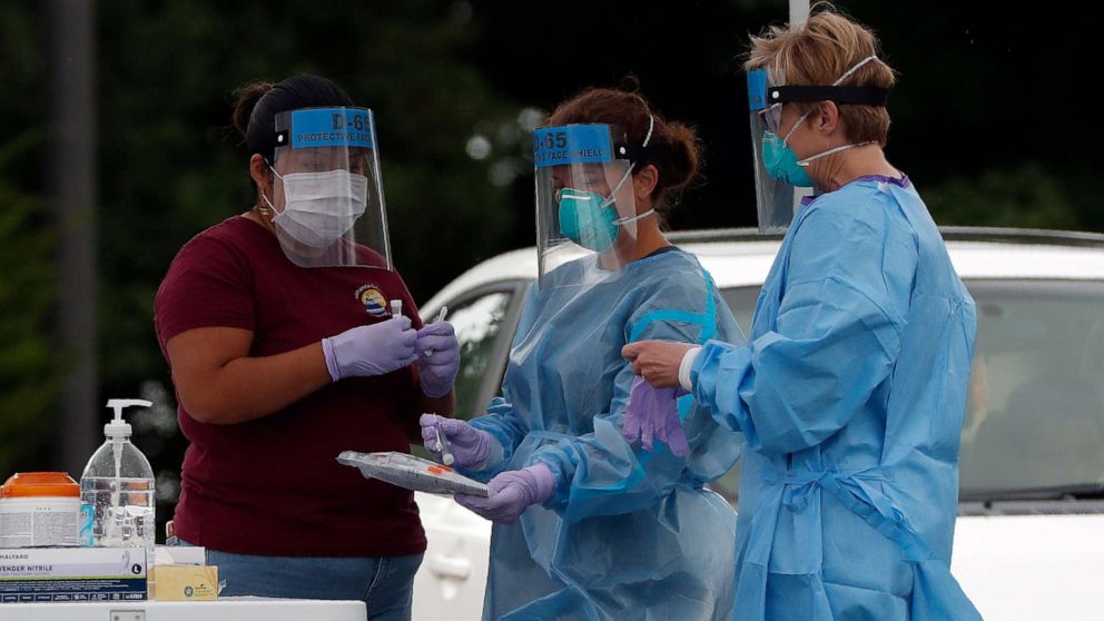 PHOTO: Medical personnel handle test samples at a community coronavirus testing site operated by Cone Health and the county Health Department in Burlington, N.C., July 9, 2020.