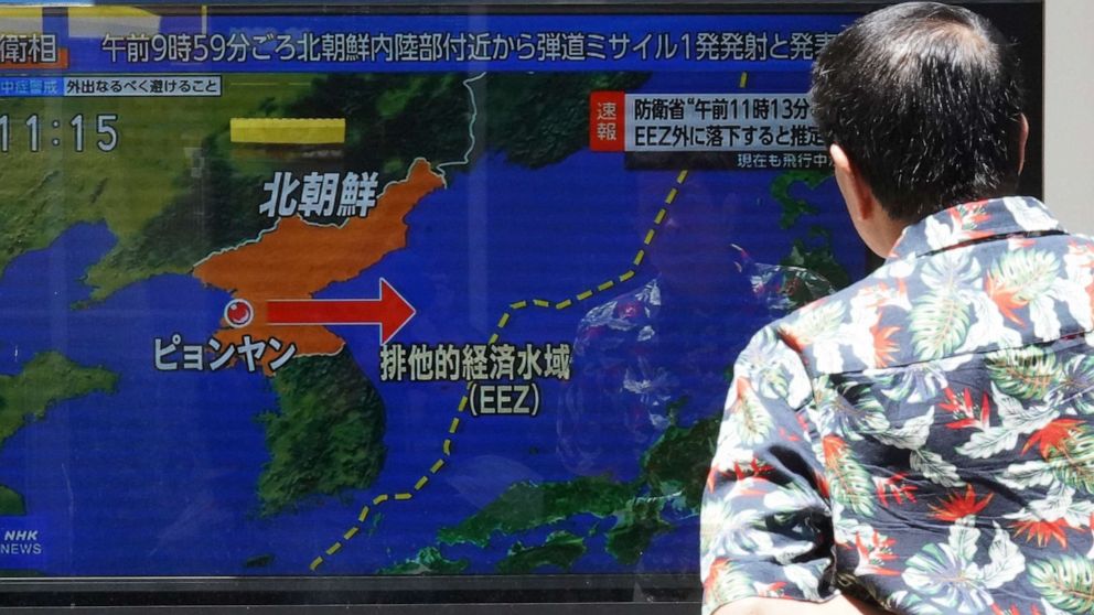 PHOTO: A man stands along a sidewalk to watch a TV showing a news program on North Korea's missile launch Wednesday, July 12, 2023, in Tokyo.
