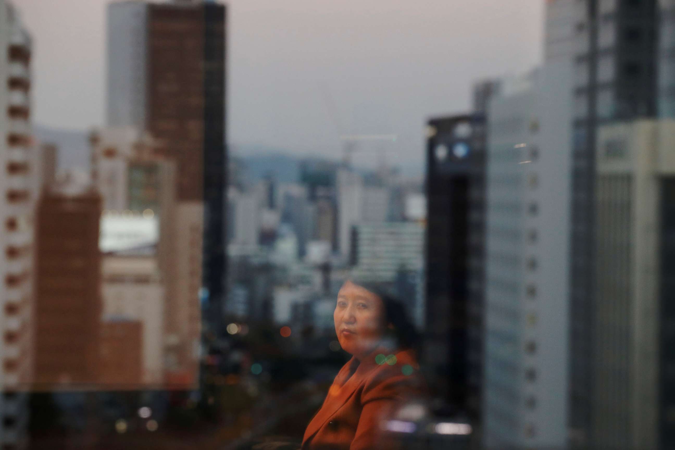 PHOTO: Kim Ryon Hui, 48, is reflected on a window as she poses for a photograph in Seoul, South Korea, Nov. 14, 2017.