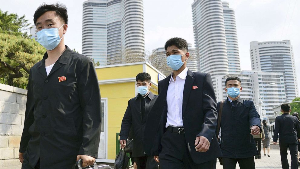 PHOTO: People wear face masks walk in Pyongyang, North Korea on May 6, 2022.