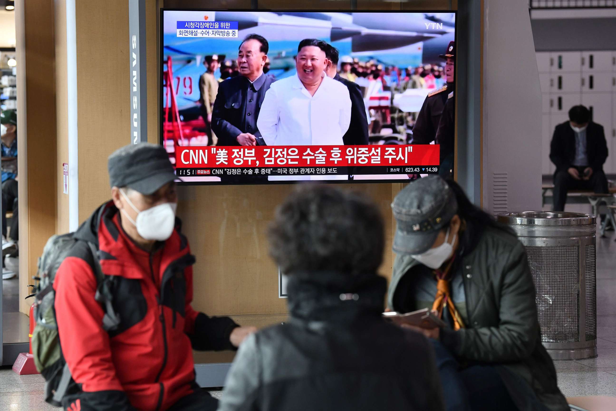PHOTO: People watch a television news broadcast showing file footage of North Korean leader Kim Jong Un, at a railway station, in Seoul on April 21, 2020.