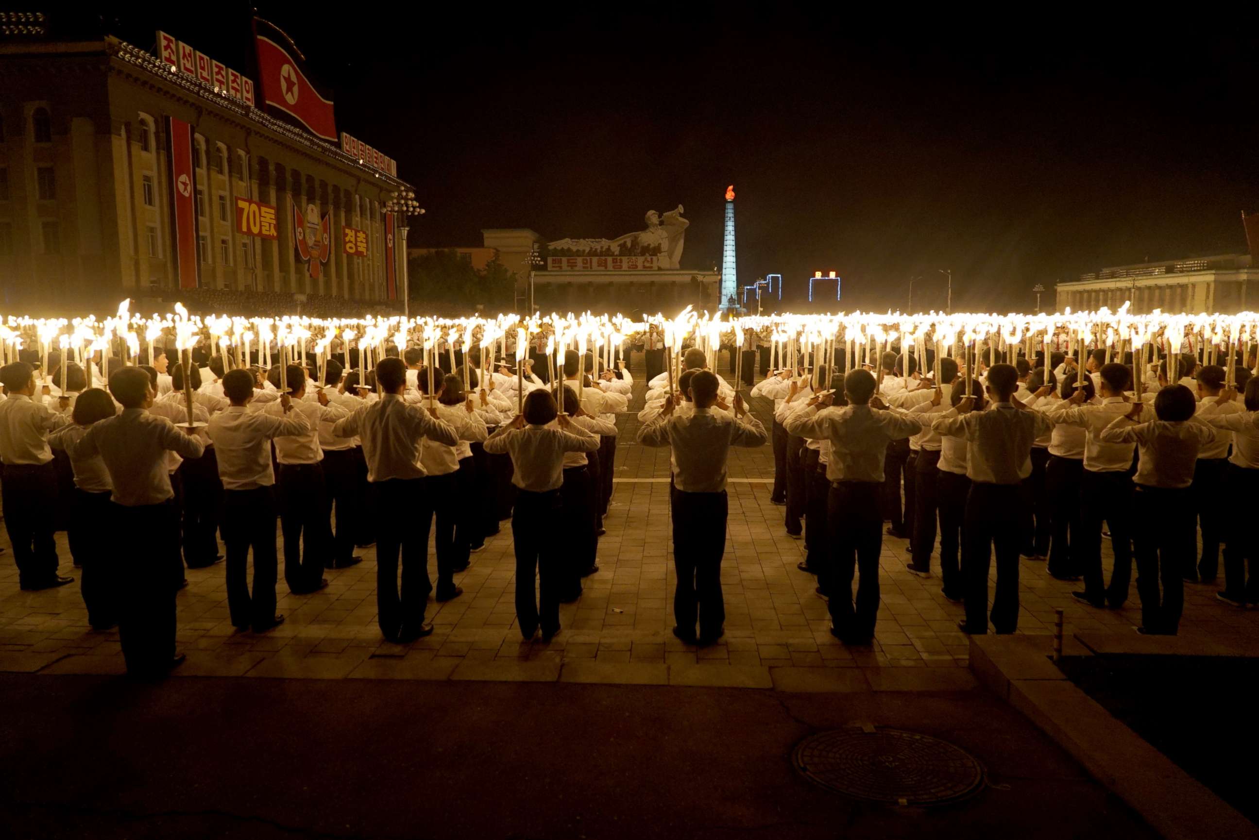PHOTO: North Korean university and high school students participate in North Korea’s 70th anniversary celebrations, known as the Torchlight Parade.