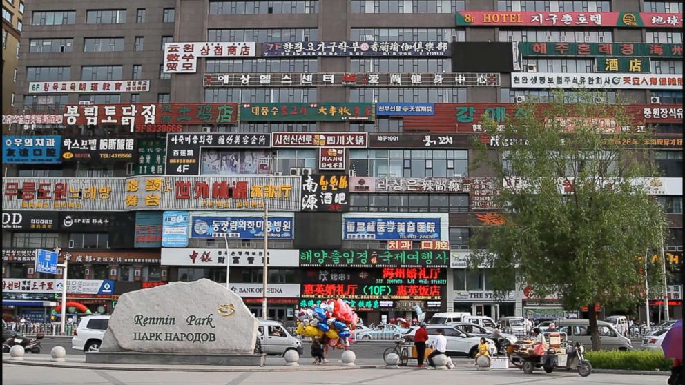 PHOTO: Signs in both Chinese and Korean can be seen on the side of building across from the People's Park or Renmin Park in Yanji, China, the largest city in China's Yanbian Korean Autonomous Prefecture.