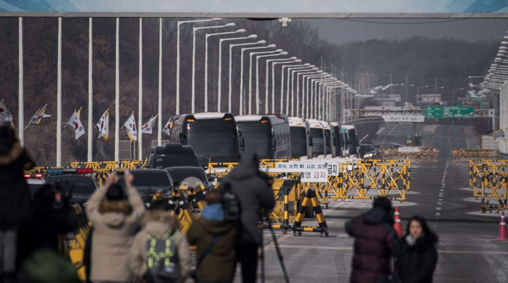 PHOTO: Busses carrying a 280-member delegation of North Korean cheerleaders crosses a checkpoint on Tongil bridge after arriving in South Korea, in Paju on February 7, 2018. 