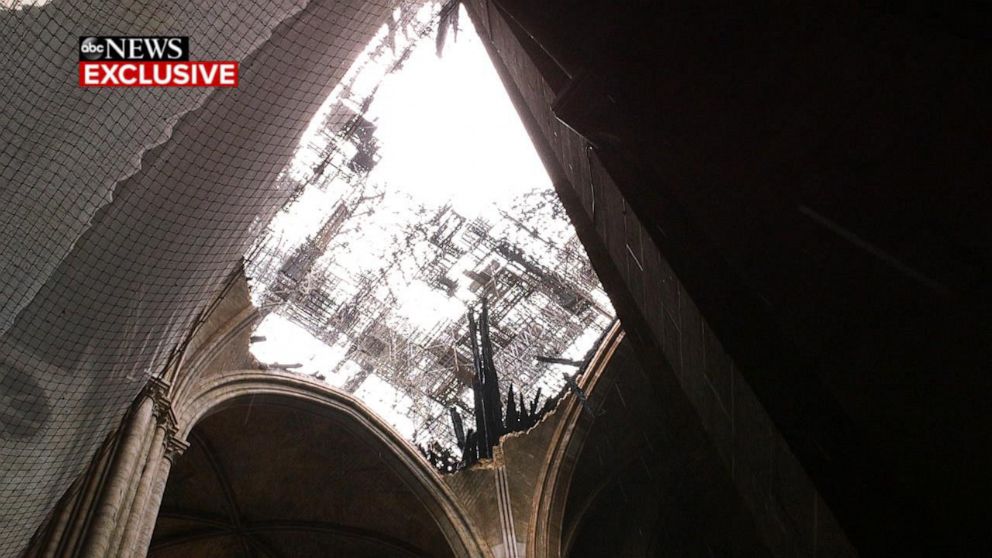 PHOTO: Netting covers a hole in the roof of Notre Dame cathedral in Paris to help block further debris a month after a fire destroyed a section of the roof in April 2019.