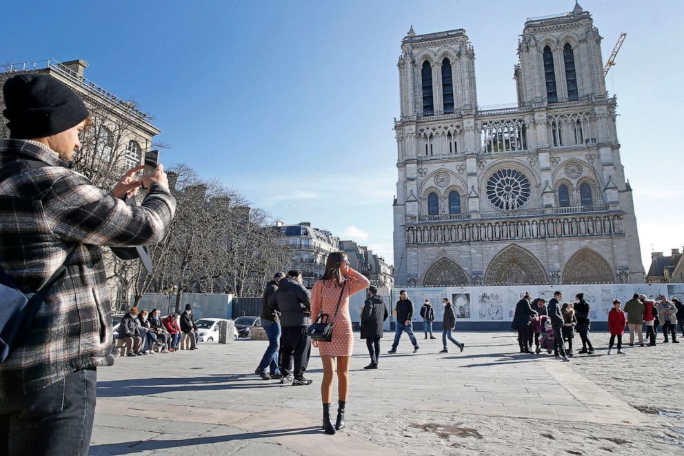 PHOTO: A woman poses in front of Notre-Dame de Paris Cathedral almost three years after fire ravaged the emblematic monument on Feb. 15, 2021 in Paris, France.