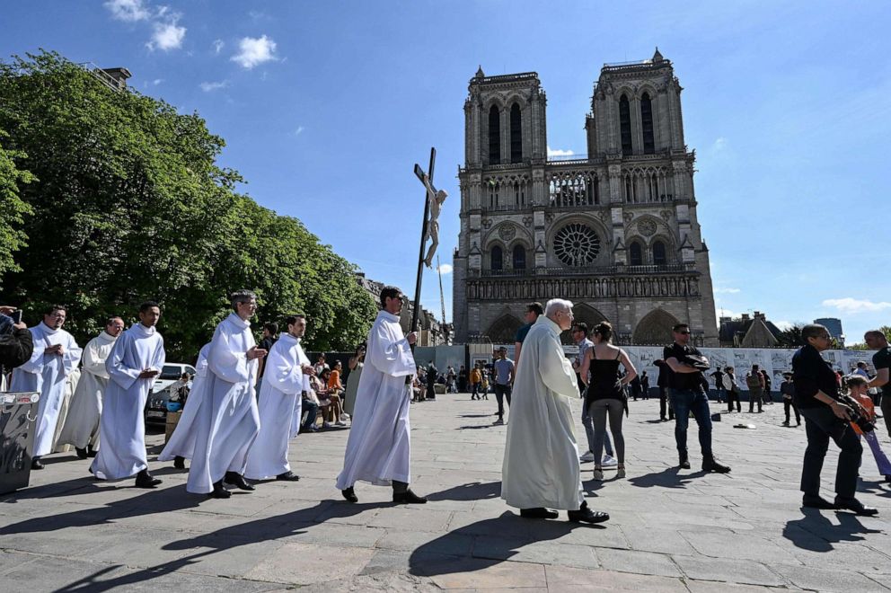 PHOTO: Catholic clerics walk during a procession on the square in front of the Notre-Dame cathedral in Paris on April 15, 2022, during a public prayer gathering to mark the third anniversary of a fire that partially destroyed the cathedral.