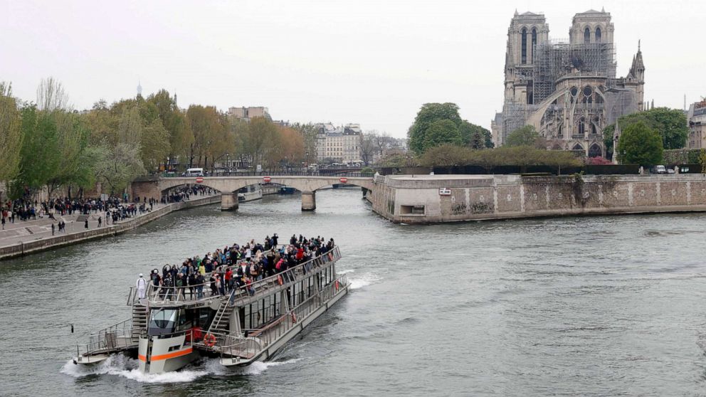 PHOTO: A tourist boat sails on the river Seine near Notre-Dame-de-Paris on April 16, 2019 in the aftermath of a fire that devastated the cathedral.