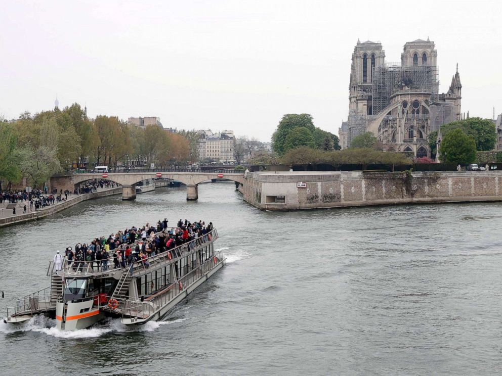 PHOTO: A tourist boat sails on the river Seine near Notre-Dame-de-Paris on April 16, 2019 in the aftermath of a fire that devastated the cathedral.
