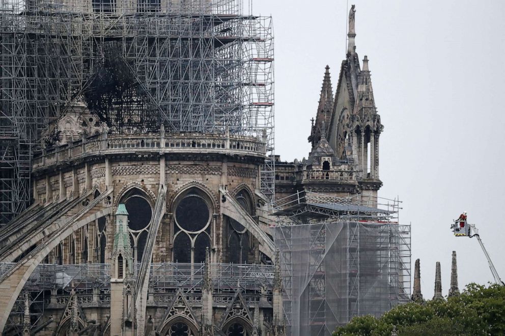 PHOTO: A firefighter stands in an aerial lift near the burnt roof after a massive fire destroyed the roof of the Notre-Dame Cathedral in Paris, April 16,  2019.