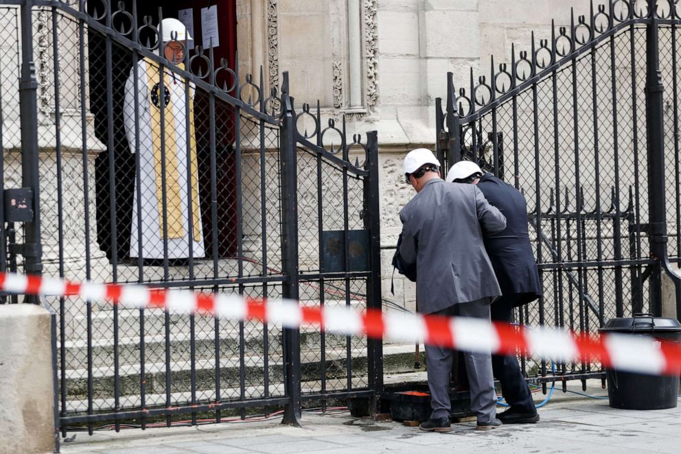 PHOTO: TOPSHOT - Notre-Dame de Paris cathedral's rector Patrick Chauvet greets people arriving for the first mass of the Notre-Dame de Paris cathedral two months after the fire, on June 15, 2019 in Paris.