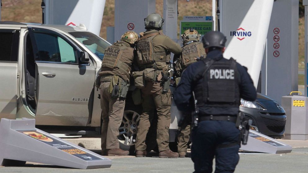 PHOTO: Royal Canadian Mounted Police officers prepare to take a suspect into custody at a gas station in Enfield, Nova Scotia, April 19, 2020.