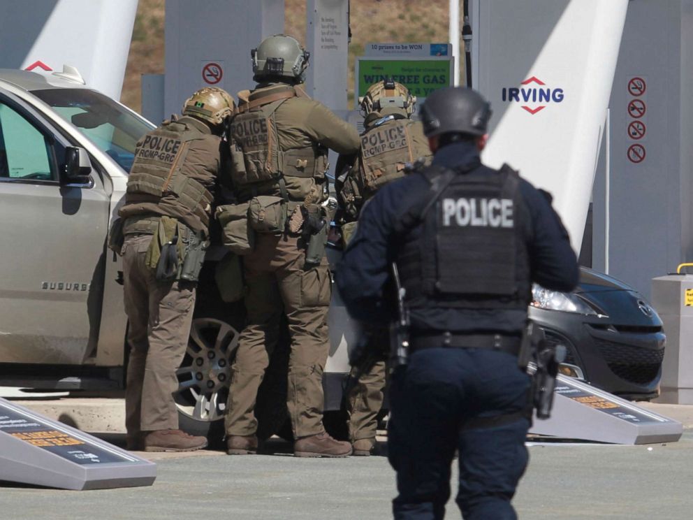 PHOTO: Royal Canadian Mounted Police officers prepare to take a suspect into custody at a gas station in Enfield, Nova Scotia, April 19, 2020.