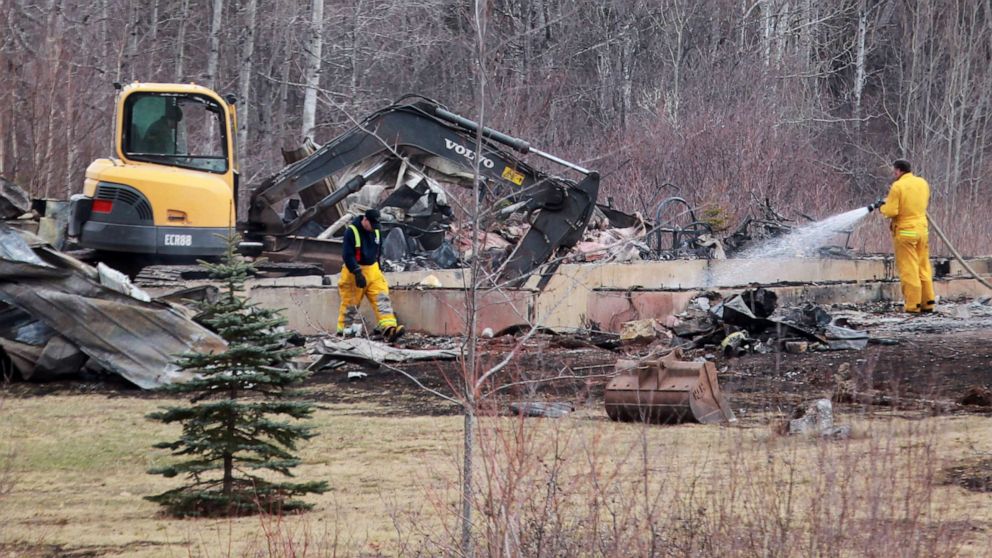 PHOTO: Wentworth volunteer firefighters douse hotspots as an excavator digs through the rubble of a destroyed home linked to Sunday's deadly shooting rampage on April 20, 2020 in Wentworth Centre, Nova Scotia, Canada. 