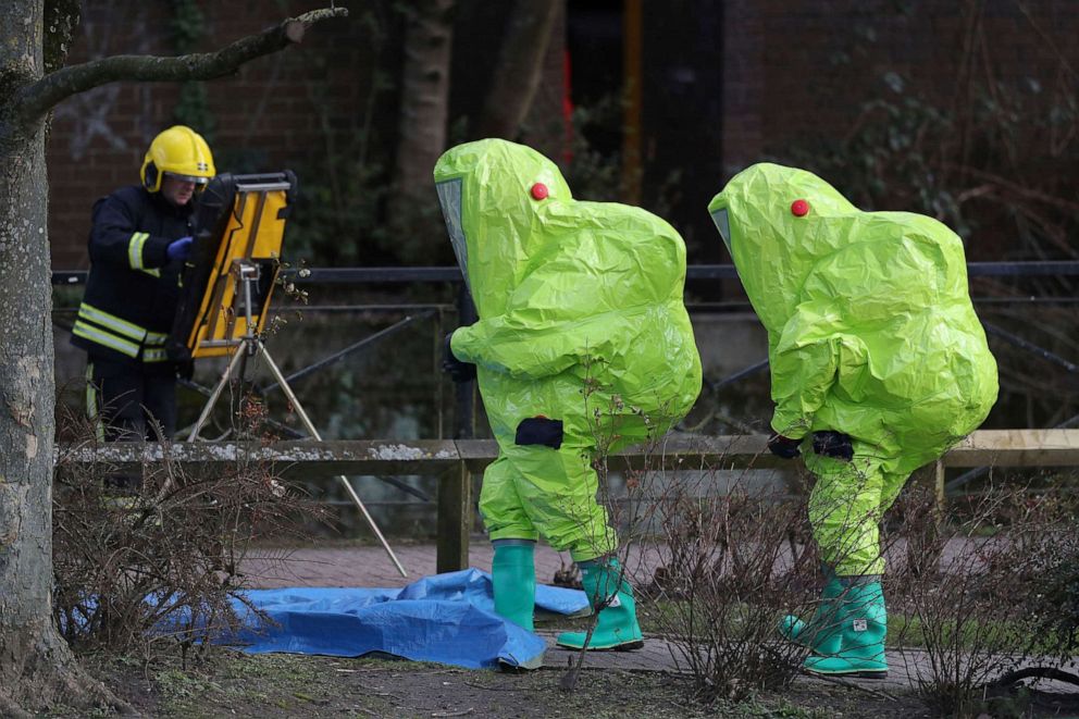 PHOTO: In this Aug. 3, 2018, file photo, people in hazmat suits wait for decontamination after securing a tent over a bench in Salisbury, where former Russian double agent Sergei Skripal and his daughter were found critically ill by exposure to Novichok.