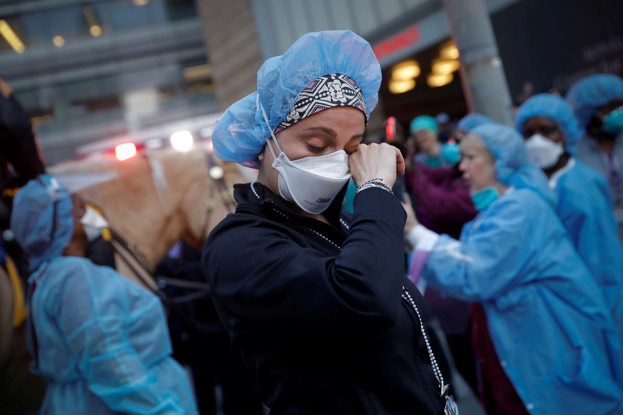 PHOTO: A nurse wipes away tears as she stands outside NYU Langone Medical Center in Manhattan as New York Police Department (NYPD) Mounted Police and other units came to cheer and thank healthcare workers at 7pm, April 16, 2020.