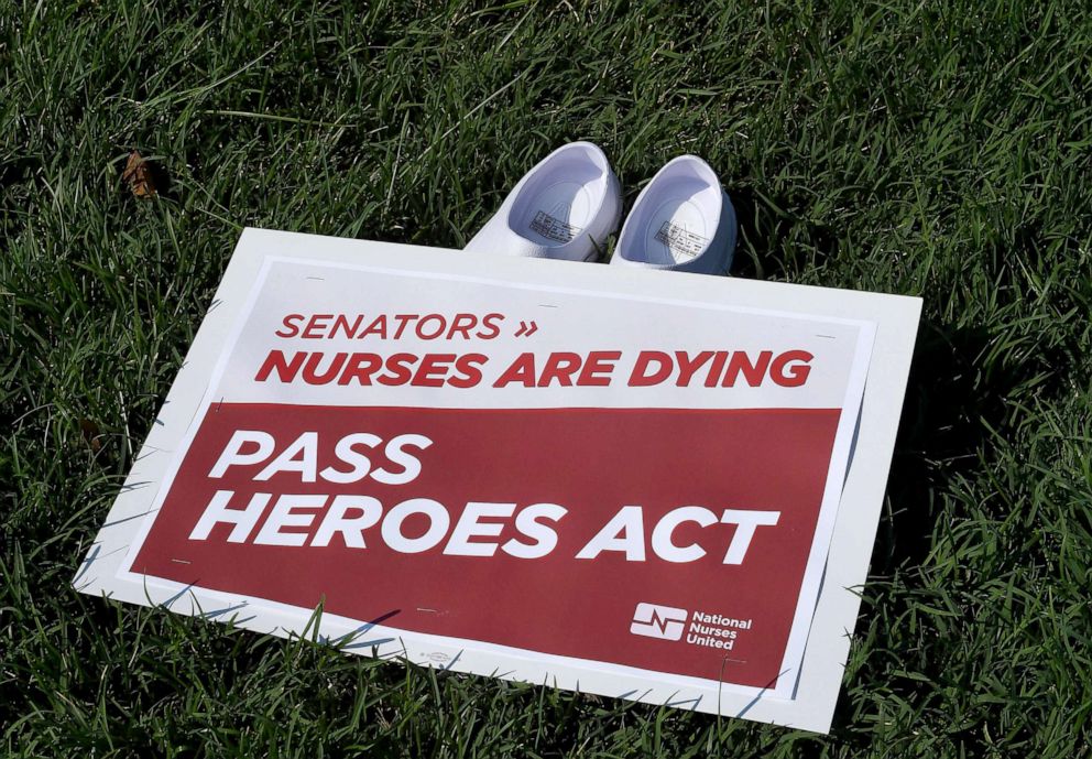PHOTO: National Nurses United (NNU) display 164 white clogs shoes outside the US Capitol to honor the more than 160 nurses who have lost their lives from COVID-19 in the United States, in Washington, DC, July 21, 2020.
