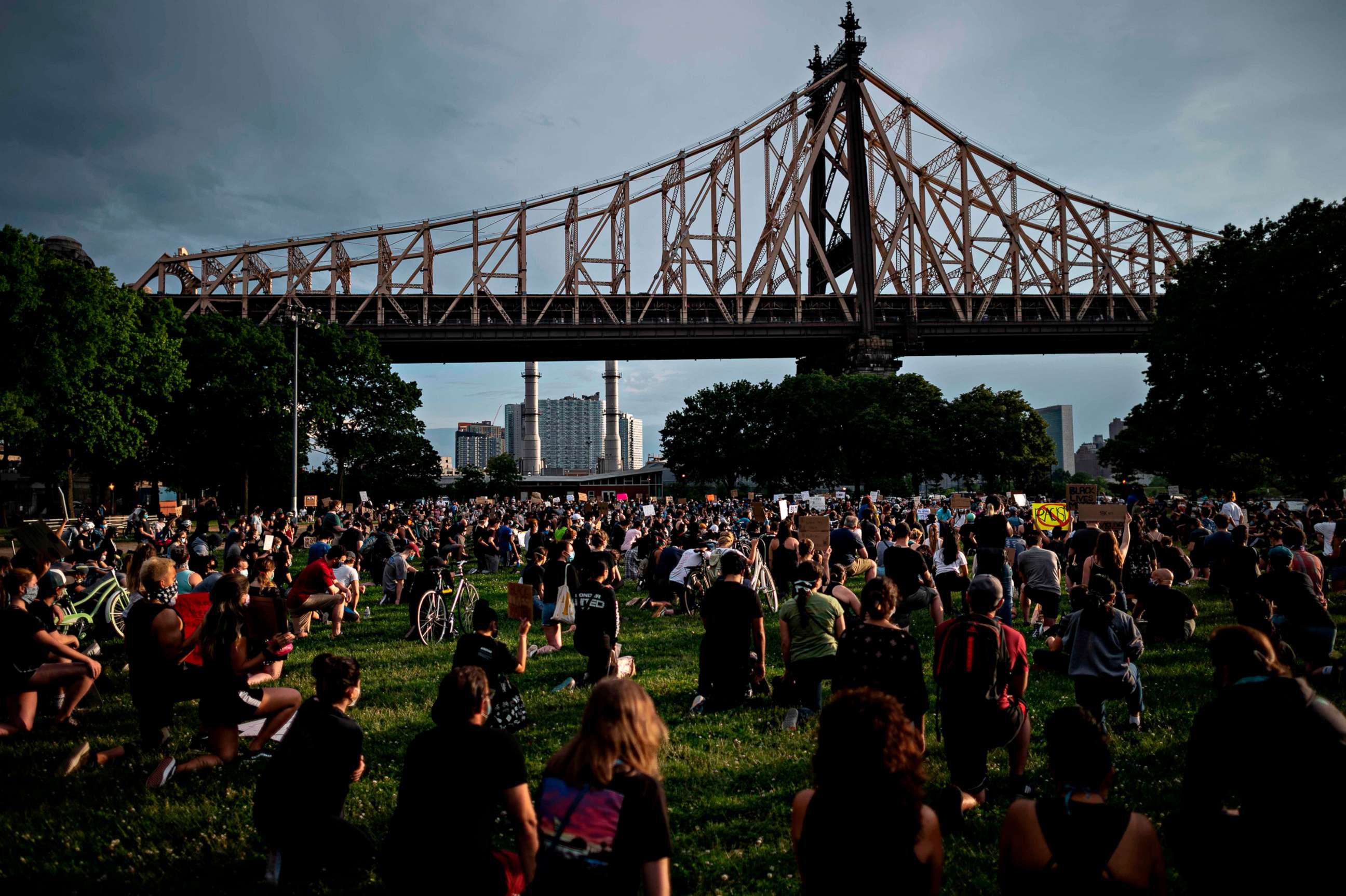 PHOTO: Protesters kneel and hold signs as they take part in a Black Lives Matter vigil, on June 3, 2020, in the Queens borough of New York City.