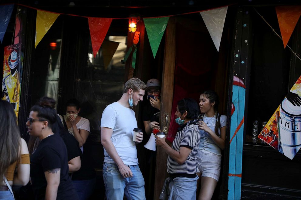 PHOTO: People drink outside a bar during the reopening phase of the coronavirus pandemic in the East Village neighborhood of New York City, June 13, 2020.