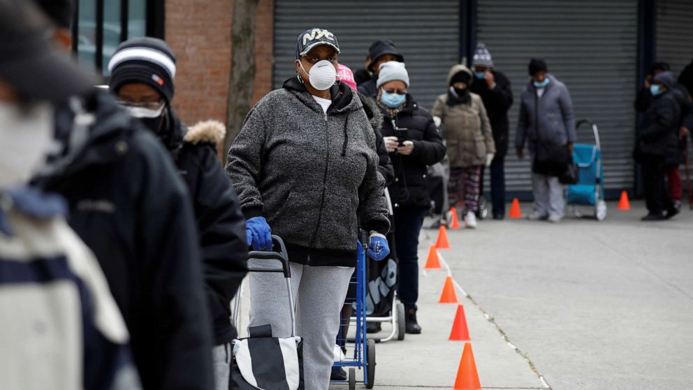 PHOTO: People wearing protective masks wait in line for donated food distribution at the Queensbridge Houses, a public housing complex, during the outbreak of the coronavirus disease (COVID-19) in the Queens borough of New York, April 21, 2020.