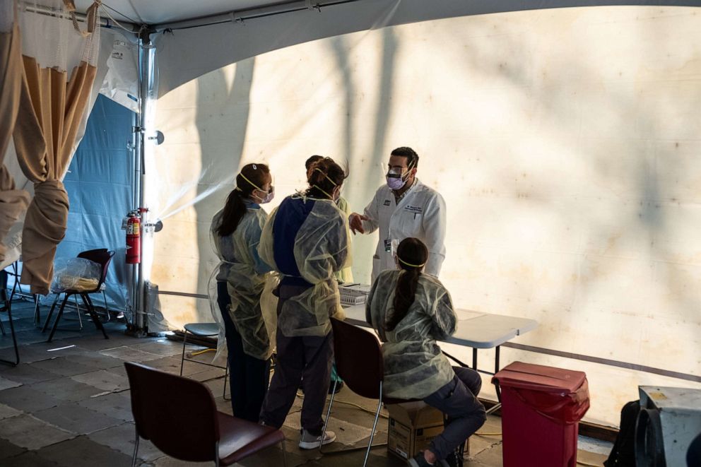 PHOTO: Doctors wait to test hospital staff with flu-like symptoms for coronavirus (COVID-19) in set-up tents to triage patients outside at St. Barnabas hospital in the Bronx borough of New York City, March 24, 2020.
