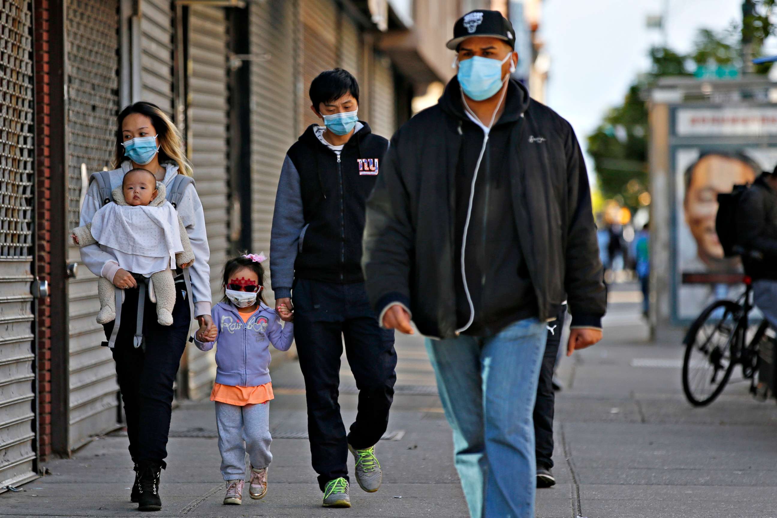 PHOTO: People walk past shuttered stores in the Sunset Park neighborhood of Brooklyn, New York, during the coronavirus outbreak, May 11, 2020.