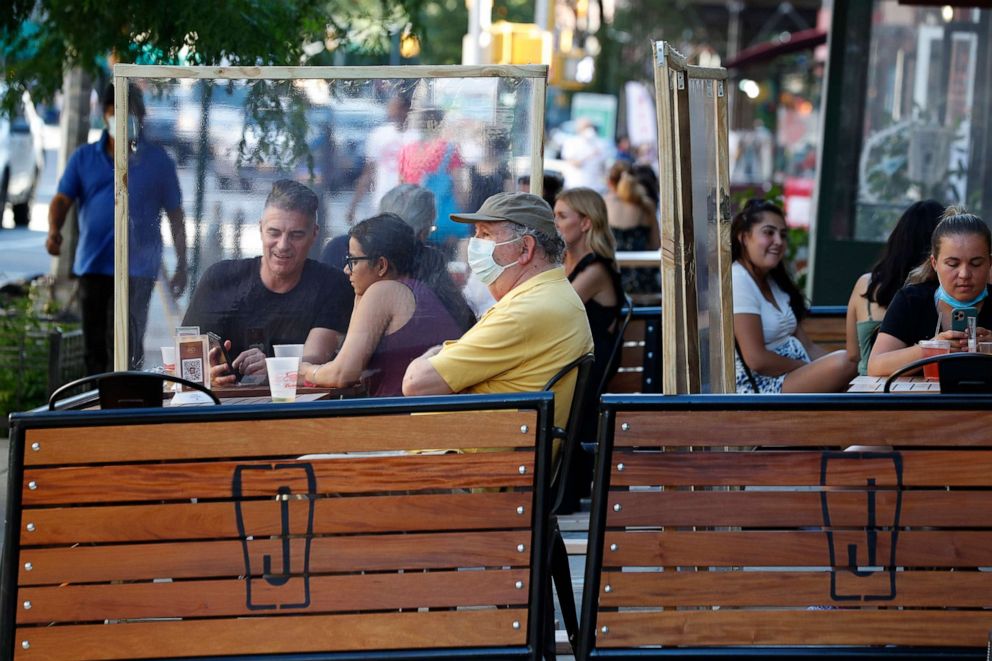 PHOTO: Plastic partitions separate patrons at Jake's Dilemma the first day of the phase two reopening of the city during the current coronavirus outbreak in New York City, June 22, 2020, in New York.