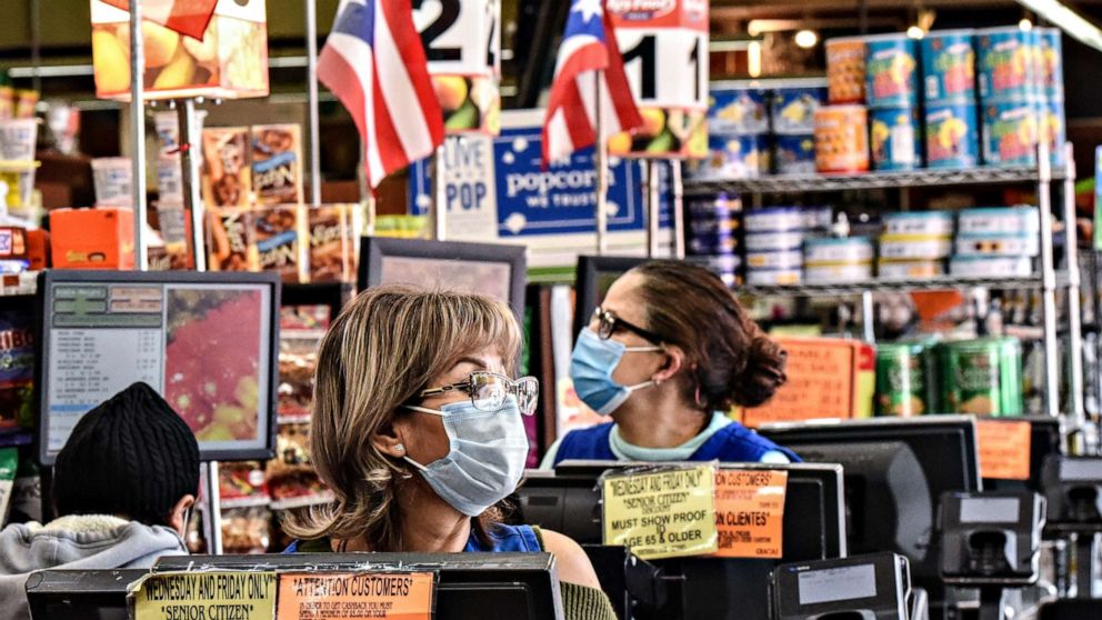PHOTO: Cashiers work in a grocery store in the Bushwick neighborhood of Brooklyn during the COVID-19 pandemic,  on April 2, 2020, in New York City.