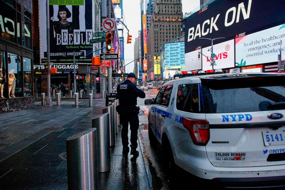 PHOTO: A NYPD officer patrols Times Square as rain falls on March 28, 2020 in New York City.