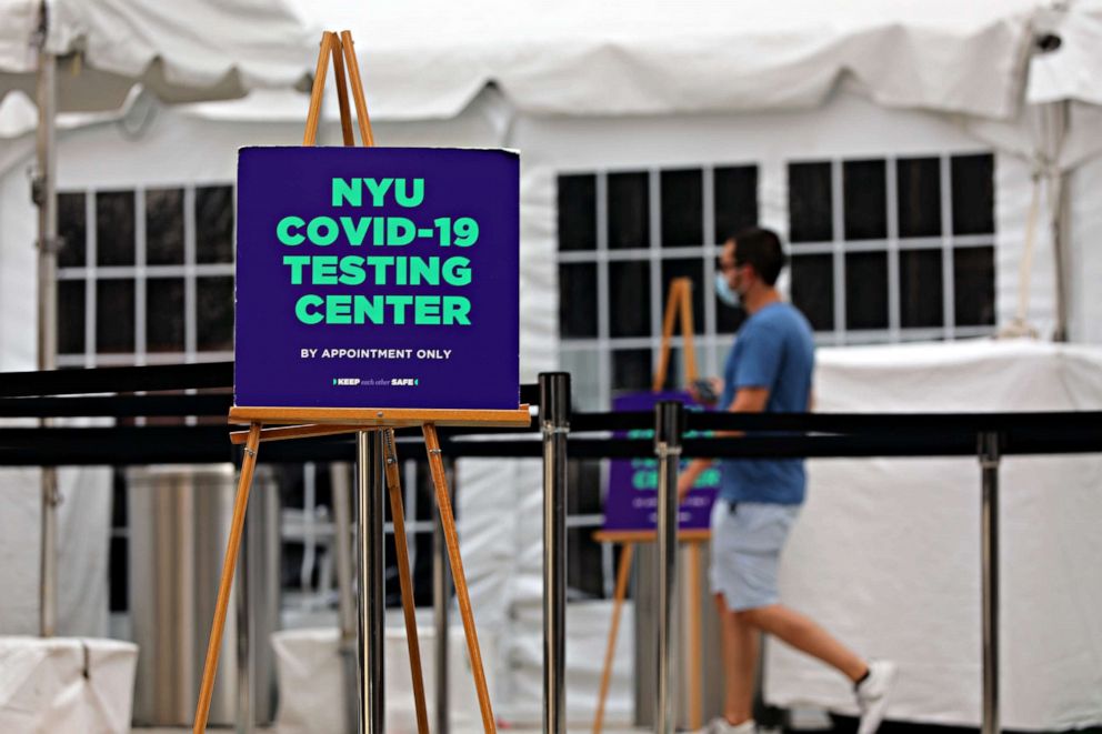 PHOTO: A student at New York University (NYU) walk outside of a COVID-19 test site at its business school on Aug. 25, 2020, in New York City.