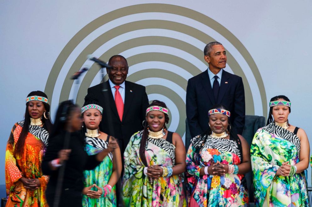 PHOTO: South African President Cyril Ramaphosa and former President Barack Obama stand on stage behind the Soweto Gospel Choir, during the 2018 Nelson Mandela Annual Lecture at the Wanderers cricket stadium in Johannesburg, July 17, 2018.